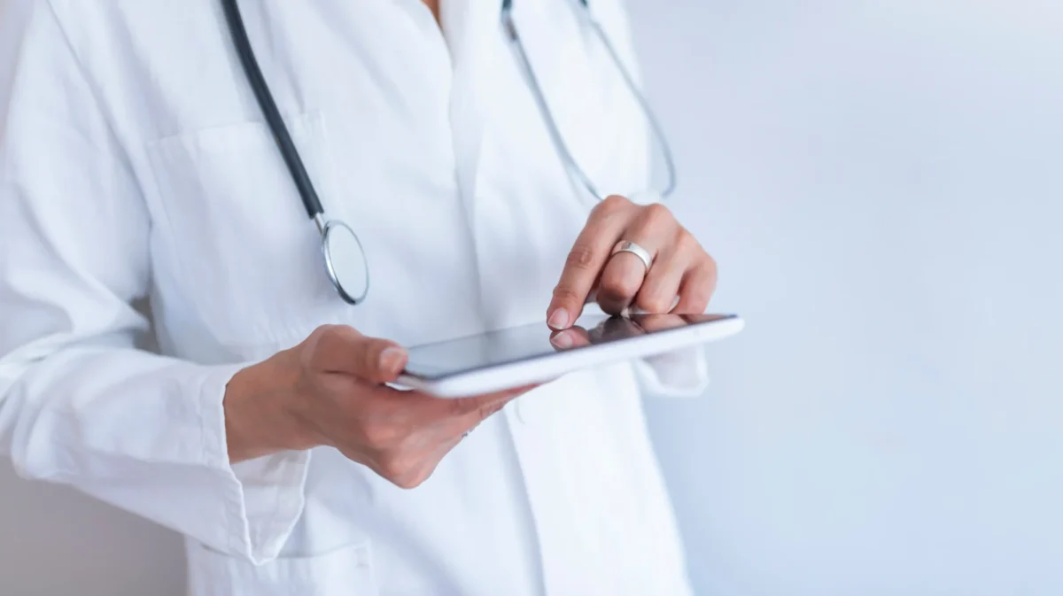 Lekarz trzymający tablet ze stetoskopem na szyi